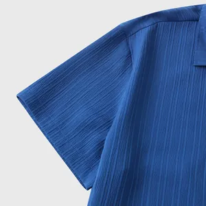Primer plano detallado del tejido con textura azul y la manga de una camisa para hombre.