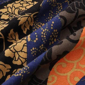 Detail view of the textured fabric and vibrant Hawaiian print patterns on the shirt