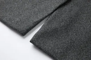 Nahaufnahme des grauen Wollmantel-Stoffs mit dicker Textur und sauberem Saum