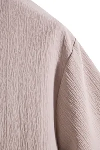 Close-up of textured breathable fabric on men's mauve short sleeve shirt detail