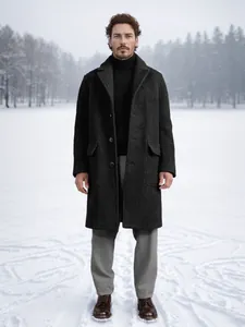 Detailed view of a man wearing a single-breasted charcoal long wool coat in snow
