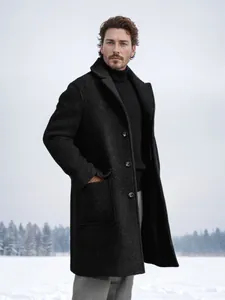 Detailed view of men's dark charcoal single-breasted wool overcoat in a snow setting
