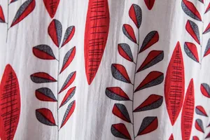 Close-up detail of red and grey leaf pattern on a white men's casual floral shirt fabric.
