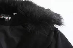 Λεπτομερής κοντινή λήψη του μαύρου γούνινου γιακά και της ετικέτας μάλλινου παλτό