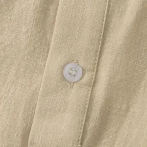Detail view of the breathable cotton linen fabric and button on a men's summer shirt