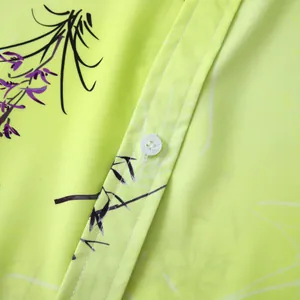 Détail d'un bouton blanc et d'un imprimé floral sur une chemise hawaïenne vert citron pour homme