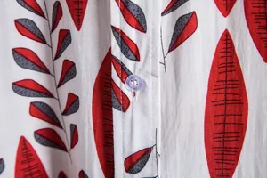 Macro view of red leaf print and button detail on men's casual summer floral shirt