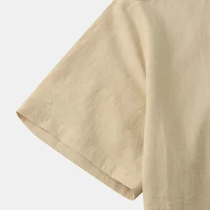 Macro detail of the breathable cotton linen fabric and sleeve seam on a beige men's shirt