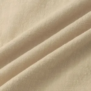 Close-up detail of breathable beige cotton linen fabric showing natural weave texture