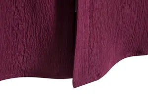 Close-up of the burgundy shirt hem showing textured fabric and neat stitching