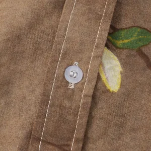 Dettaglio macro di una camicia marrone da uomo con stampa floreale e un bottone