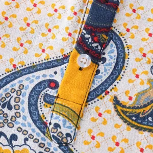 Close-up detail of the button placket on a men's Hawaiian paisley print shirt
