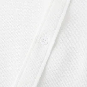 Detailed macro view of white waffle knit fabric texture and button placket on men's casual shirt