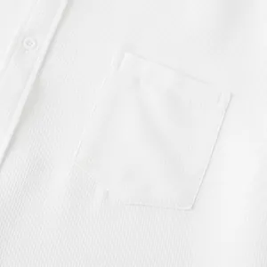 Macro view of white breathable textured fabric and pocket detail on men's casual shirt