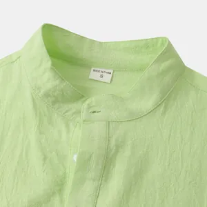 Detail of light green cotton linen mandarin collar shirt with fabric texture and size tag