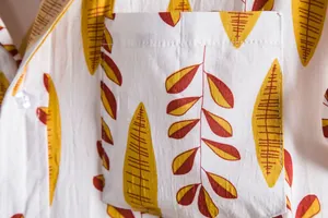 Macro view of the floral shirt pocket featuring a detailed yellow and brown leaf pattern.