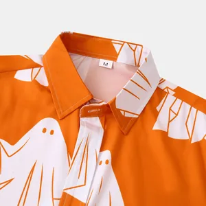 Primo piano di una camicia arancione da uomo con stampe di fantasmi bianchi divertenti.