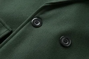 Detailansicht des dunkelgrünen Wollmischgewebes und der schwarzen Knöpfe an einem Herrenmantel