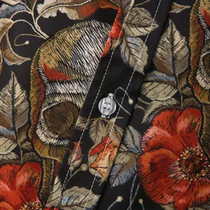 Λεπτομερής λήψη υφάσματος με vintage floral και νεκροκεφαλή μοτίβο με λευκές ραφές σε πουκάμισο