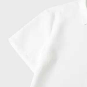 Close-up detail of a white short-sleeved casual shirt showing textured breathable fabric.