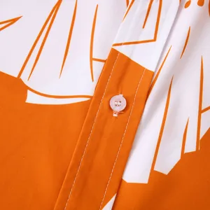 Dettaglio ravvicinato camicia da uomo a maniche corte con stampa floreale arancione e bottone