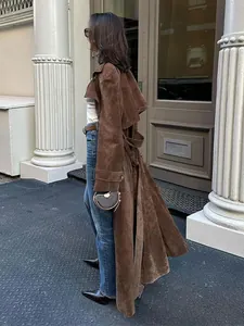 Perfil lateral de una gabardina larga vintage marrón de ante con cinturón para anudar