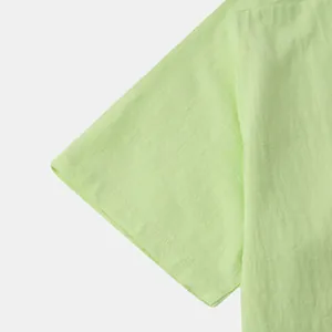 Close-up detail of light green men's cotton linen shirt sleeve and fabric texture