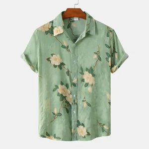 Vista dettagliata di una camicia a maniche corte verde da uomo con motivi floreali bianchi
