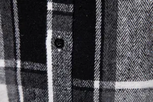 Primer plano detallado de camisa de cuadros gruesa con tejido de espiga y botón negro.