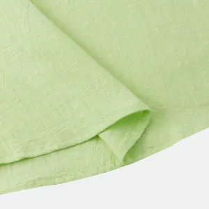 Close-up detail of light green cotton linen fabric texture and hem stitching