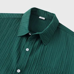 Vista de detalle de la textura plisada verde oscuro y el cuello de camisa de hombre