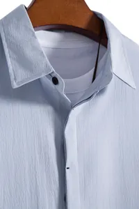 Close-up of light blue men's short-sleeve shirt featuring textured fabric and classic collar