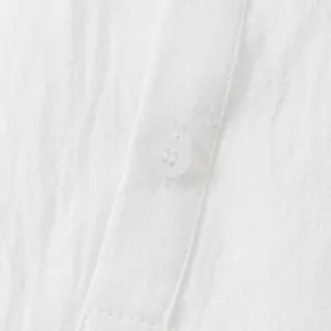 Detailed macro view of white cotton linen casual shirt button and soft breathable fabric texture