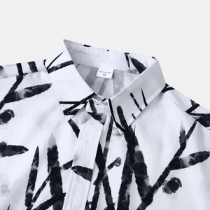 Gros plan d'un col de chemise hawaïenne blanche avec motif de branches à l'encre
