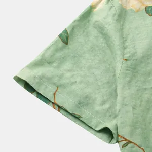 Dettaglio del polsino e della fantasia floreale su una camicia verde a maniche corte da uomo