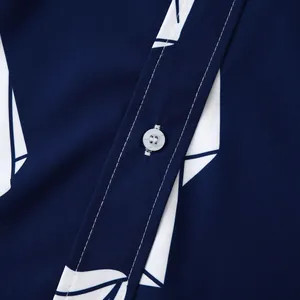 Primo piano del bottone bianco e delle cuciture precise sulla camicia blu navy a motivi