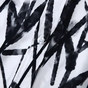 Gros plan sur le motif de bambou noir sur le tissu d'une chemise hawaïenne blanche pour homme