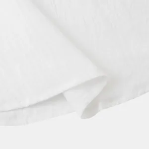 High-quality close-up showing the breathable white cotton linen fabric of a men's shirt.