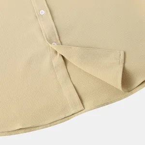 Detailed macro shot of waffle texture fabric and hem on a men's casual khaki button-down