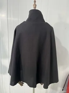 Gedetailleerd achteraanzicht van een elegante effen zwarte wollen cape op een paspopstand.