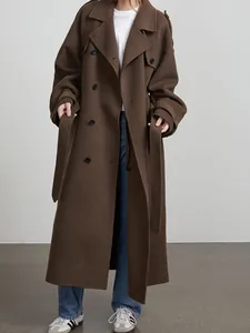 Detail showing a long brown double-breasted wool coat with an adjustable waist belt.