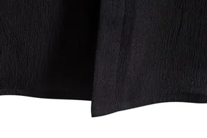 Macro view of the textured black fabric and hem of a men's short sleeve shirt
