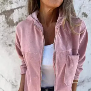 Dettaglio ravvicinato di una giacca in velluto a coste rosa con cappuccio e zip