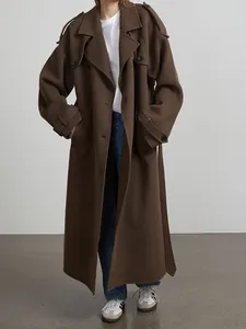 Full view of a minimalist long brown wool coat with retro lapel collar and cuff belt details.