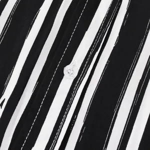 Macro detail of black and white vertical striped fabric with a clear button on a men's shirt