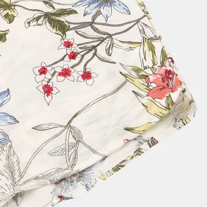 Primo piano della stampa floreale e dell'orlo di una camicia estiva da uomo.