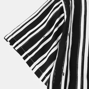 Close-up of black and white vertical striped fabric on a men's casual shirt sleeve.