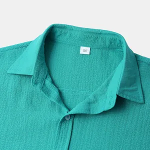 Macro view of a turquoise men's short-sleeved shirt collar with crepe fabric texture