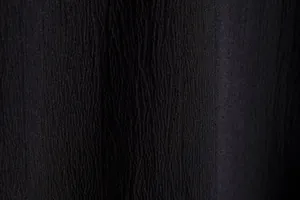 Close-up detail of black textured fabric with crinkle pattern for men's summer shirt