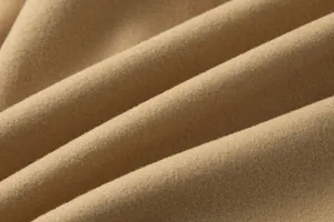 Makroansicht der dicken kamelfarbenen Wollmischgewebestruktur eines Herrenmantels.